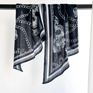 Fashionable long skinny scarf featuring chain and skull prints on a black silk-like fabric