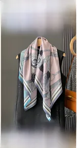 Detail view of 90x90cm floral silk scarf with rose patterns hanging on a wooden hanger