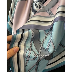 Detailed close-up of nautical rope and stripe patterns on a silky fashion scarf