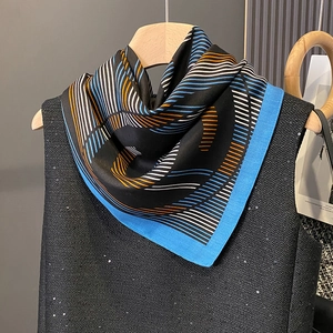 Eleganter schwarzer Schal mit blauem Karomuster auf einem Holzkleiderbügel