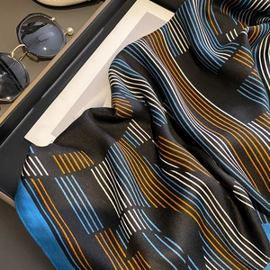 Nahaufnahme des karierten Schals mit Fischgrätenmuster und Perlen-Sonnenbrille