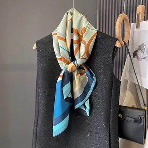 Elegant geometric silk scarf with abstract pattern styled on a black tweed vest