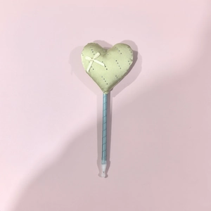 Detail des hellgrünen Satinherz-Kissens mit weißer Schleife auf einem bandumwickelten Stift