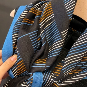 Detail eines karierten Paschmina-Schals mit orangefarbenen und blauen Streifenmustern
