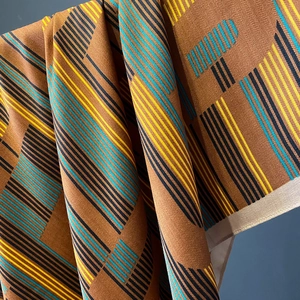 Detailaufnahme der Schal-Textur mit orangefarbenen und gelben geometrischen Mustern