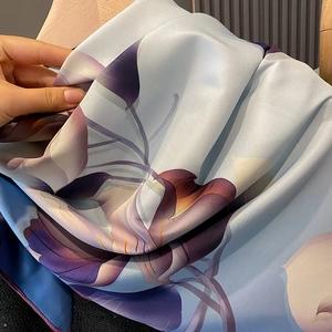 Vue détaillée d'un foulard en soie à fleurs avec bords roulés et texture lisse et douce