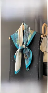 Detail of 90x90cm silk scarf featuring classic lotus and leaf print on a hanger