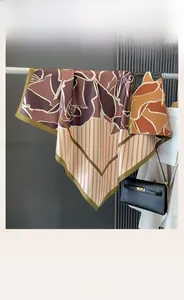 Dettaglio di un foulard quadrato in seta con motivi di rose e bordi a righe