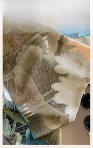 Detailed macro shot of fine machine-rolled hem and lotus print on luxury silk scarf