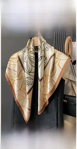 Close-up of a 90x90cm floral print silk-feel scarf with brown flower pattern on hanger