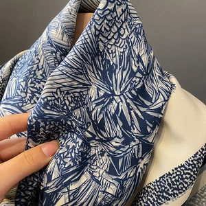Blue and white silk scarf with jungle print showing drape and satin texture
