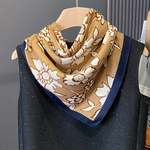 Detail of floral printed scarf showing contrast navy borders and elegant silk texture