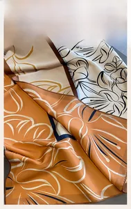 Macro detail of fine machine-rolled edges on a floral print silk scarf