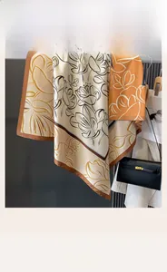 Detail of vintage double-sided silk scarf with floral patterns draped on a metal rod