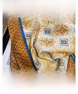 Close-up of fine stitched edges and vintage floral pattern on silky scarf fabric