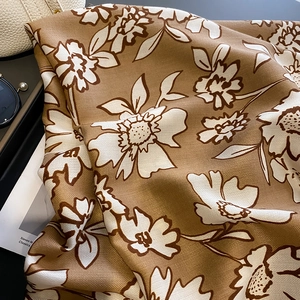 Detailed view of floral pattern scarf with herringbone weave and tan brown finish