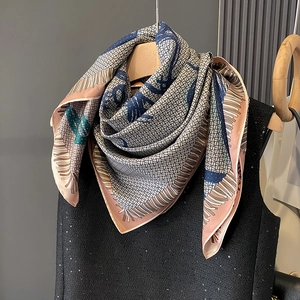 Elegant geometric print silk scarf in pink and navy hanging on a wooden hanger