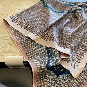 Macro view of silky floral scarf with blue and grey abstract patterns and soft texture