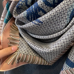 Close-up of geometric pattern silk scarf showing luxury fabric texture and rolled edges