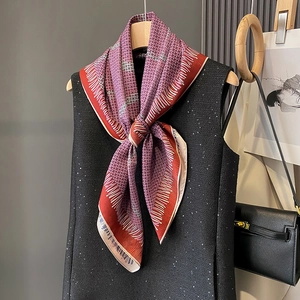 Elegant geometric patterned silk scarf in burgundy and cream styled on a tweed top