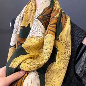Macro shot of vintage floral scarf showing vibrant yellow patterns and textured fabric