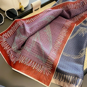 Detailed view of geometric printed silk scarf with elegant woven texture and fringe pattern