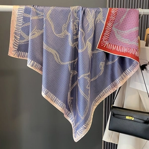 Detail of silk square scarf showing geometric blue purple prints and fine fringe edges