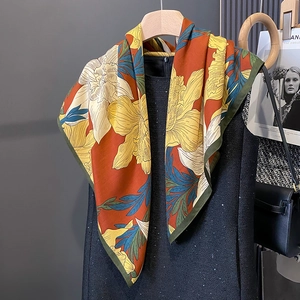 Floral print 90cm silk scarf in burnt orange and peacock blue styled on a black dress