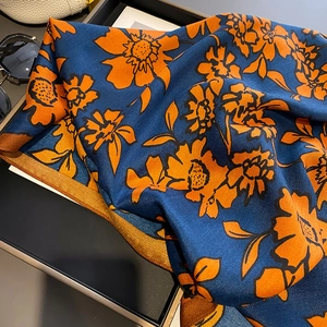 Detail of navy blue and orange floral silk scarf with premium twill weaving texture