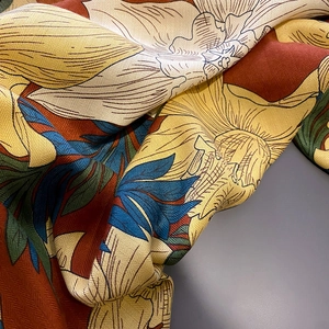 Detailed macro view of herringbone weave silk scarf with colorful vintage floral print