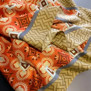 Detailed macro view of bohemian geometric jacquard patterns on vintage printed silk scarf