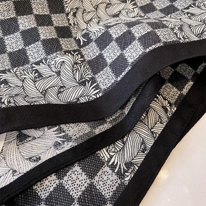 Close-up of premium jacquard scarf showing black and white geometric woven texture
