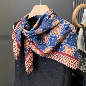 Detailed close-up of vintage bohemian floral silk scarf on a hanger with elegant drape