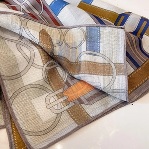 Silk neck scarf with blue and orange equestrian prints and harness chain patterns