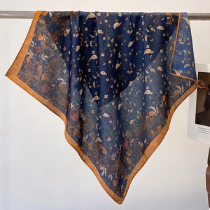 Elegant navy blue silk scarf with gold floral patterns hanging on a metal rack