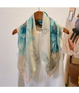 Detail of a floral cotton-linen feel scarf with blue butterfly print hanging on a hanger