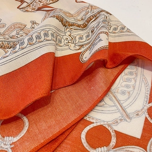 Elegant equestrian silk scarf with horse bit pattern in classic orange and cream colors