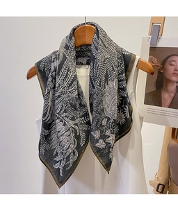 Detailed pattern of a vintage floral print scarf draped on a white sleeveless top