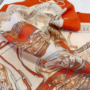 Detailed view of the twill texture and equestrian harness pattern on the square silk scarf