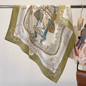 Detail of elegant ivory square scarf with olive green border and vintage horse bit patterns