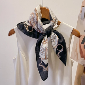 Detail of vintage equestrian silk scarf with horsebit chain pattern on white shirt