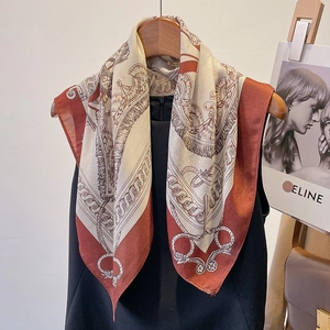Detail of silk-feel square scarf with equestrian harness print on wooden hanger