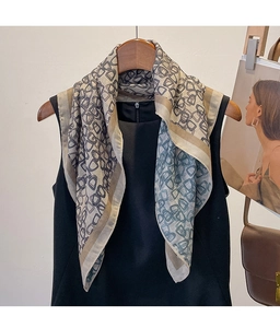 Macro detail of geometric pattern scarf with blue and khaki lines on grey-white fabric