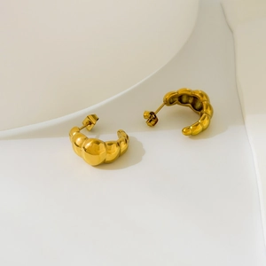 Detailed close-up of 18K gold-plated croissant dome stud earrings on an elegant display