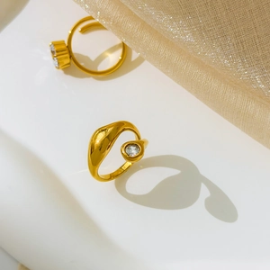 Dettaglio di anelli bypass placcati oro 18K con pietre di zircone cubico rotonde