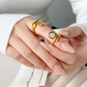 Dettaglio anello in titanio placcato oro 18K con zirconia tonda sulla mano