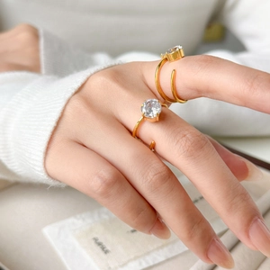 Dettaglio di anelli placcati oro 18K con zirconi luminosi e design a gambo diviso