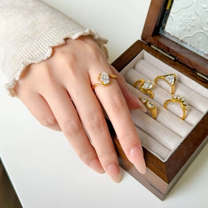 Detailed view of 18K gold rings with marquise and teardrop cubic zirconia on hand