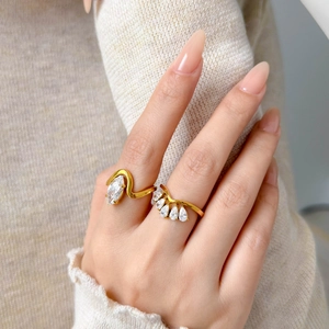 Close-up of gold plated marquise and teardrop zircon crown rings on fingers