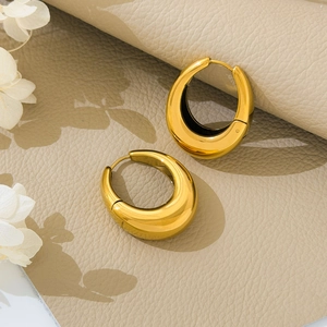 Golden chunky teardrop hoop earrings with high-polish finish on premium leather background
